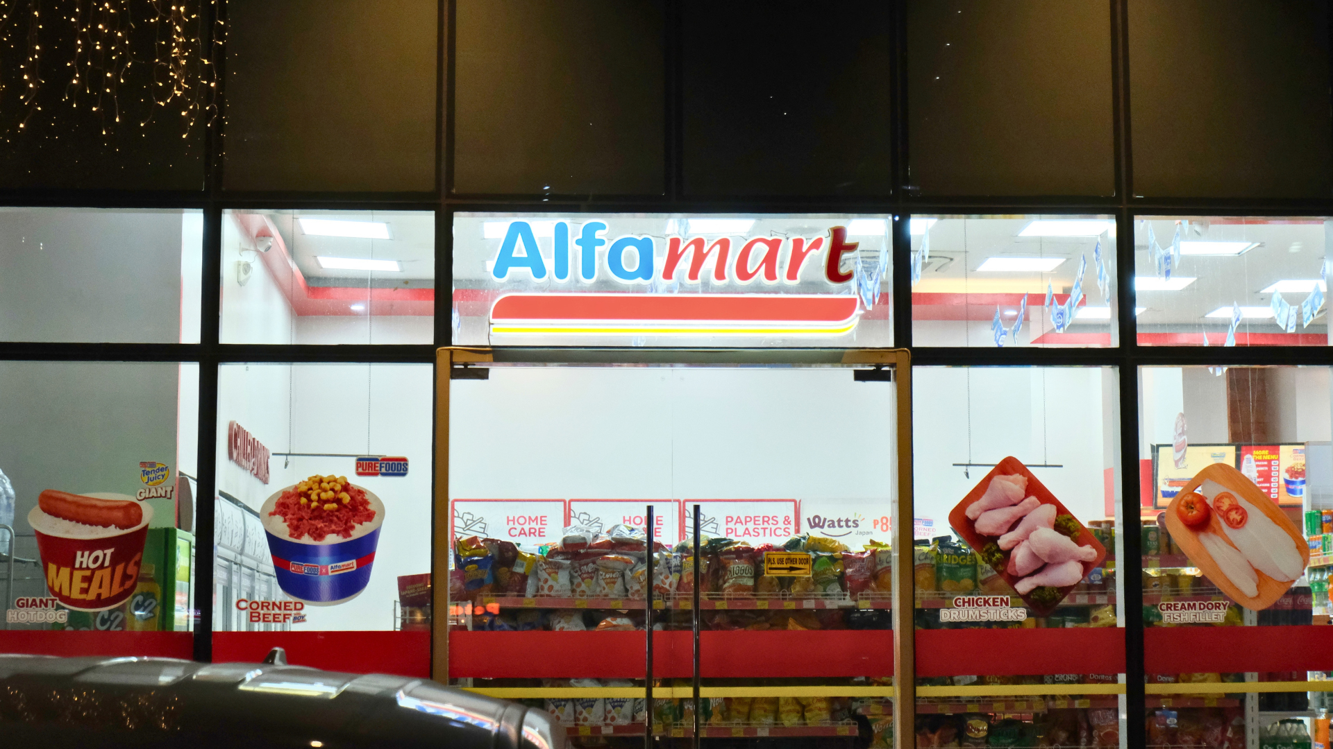 Alfamart convenience store storefront at night